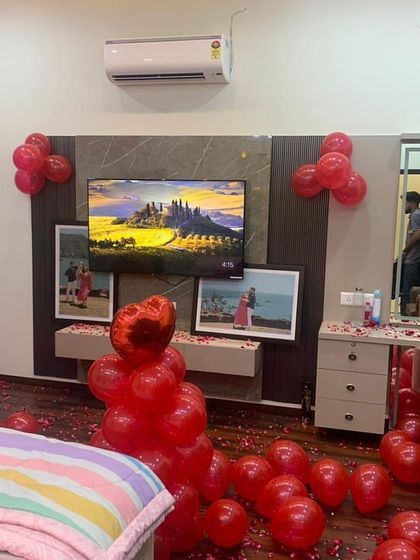 A wider view of the romantic room setup, showing how we use balloon clusters and floor decorations to fill the space and create a complete celebratory look.