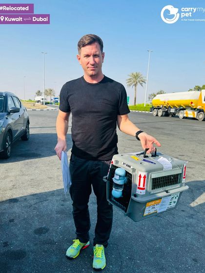 Gucci the cat is ready for the next leg of his journey after arriving in Dubai from Kuwait, with his owner holding the IATA-approved crate.
