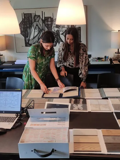 Two of our designers collaborating over material samples and plans. This image highlights the detailed, hands-on work that goes into every design decision.