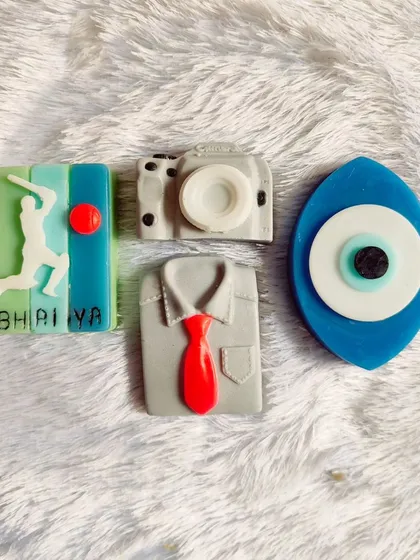 A set of soaps perfect for him: a cricket-themed "Bhaiya" soap, a camera, a shirt and tie, and an evil eye.