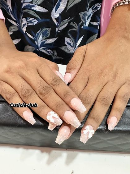 A lovely and delicate set featuring coffin-shaped nails with a sheer, shimmery base. The look is completed with small, sculpted 3D white bows on the ring fingers.