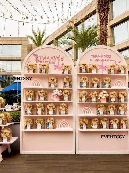 The party favor display, elegantly arranged on custom-built pink shelves for guests to take home a piece of the magic.
