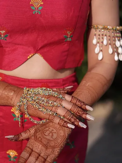 A close-up of the colourful hand harness and shell armlet, showing the intricate details and textures.