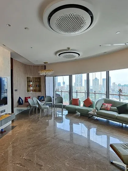 For the Jesrani Residence, the client requested a minimalist aesthetic. We designed this expansive living room to feel calm and uncluttered, using a gentle color scheme and a curved sofa that follows the building's form, all while maximizing the stunning panoramic city views.