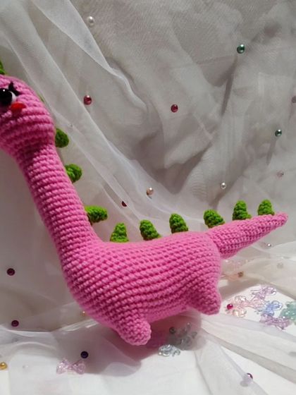A side view of the adorable pink dinosaur.
