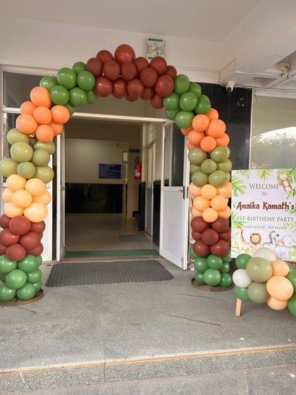 A welcoming balloon arch in jungle-themed colors of green, orange, and brown. This entrance sets the tone for the safari adventure awaiting guests inside.