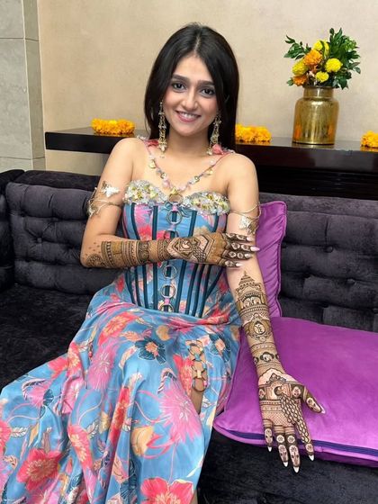 A beautiful bride in a modern outfit, showing off her traditional mehandi. Our designs can complement any style.