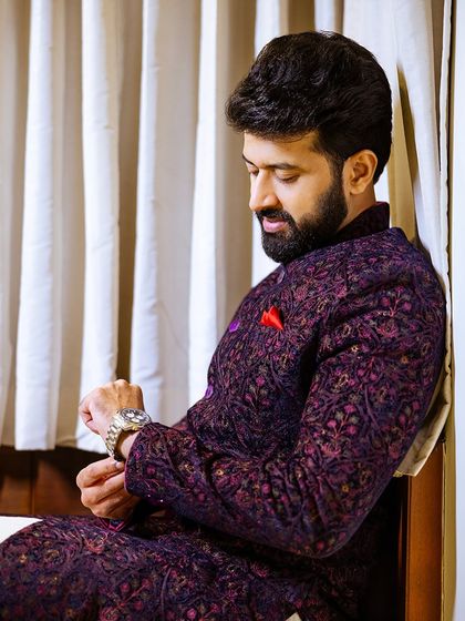 A candid shot of the groom adjusting his watch, a classic and timeless groom portrait.