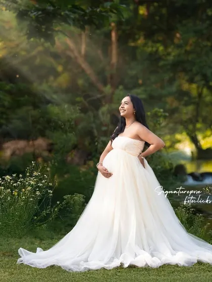 An angelic portrait in a flowing white gown, with sunbeams breaking through the trees for a divine effect.