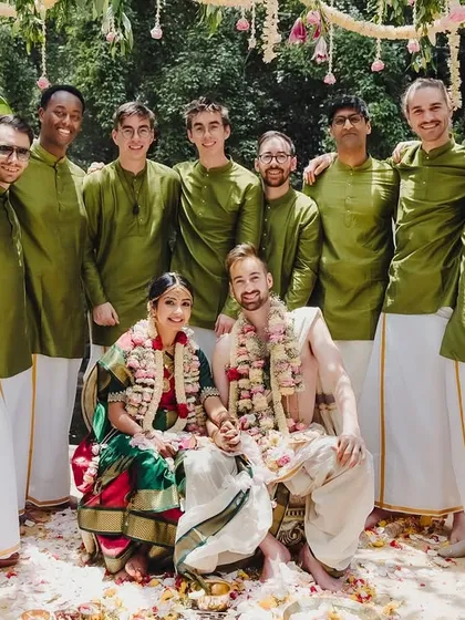 The couple poses with the groomsmen, who have embraced Indian tradition by wearing matching kurtas and mundus.