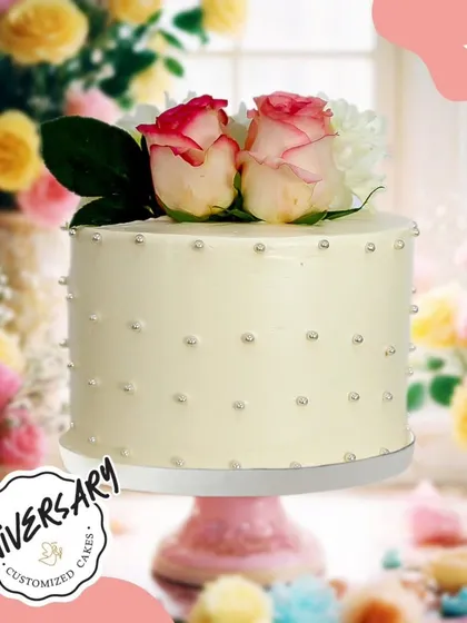 A chic and simple anniversary cake, topped with fresh roses and dotted with silver pearls. This minimalist design is both modern and timelessly romantic.