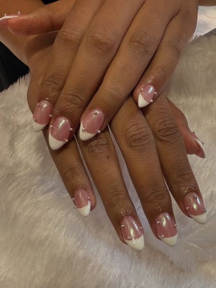 A simple yet edgy take on the classic French. This design features a clean white tip on a sheer base, with tiny silver studs placed along the smile line for a modern, studded look.