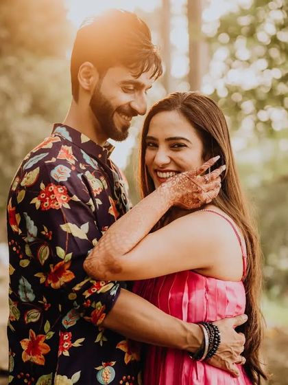 A sun-kissed pre-wedding portrait. The warm light and the couple's happy embrace make for a perfect, romantic memory.