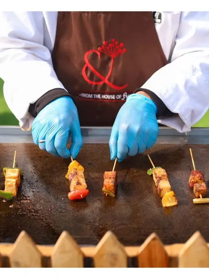 A close up of a chef arranging vegetarian skewers on a hot grill. This shot highlights the fresh ingredients and careful preparation involved in our vegetarian barbecue options.