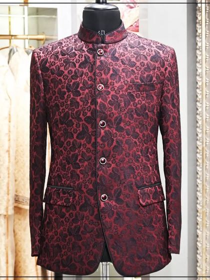A Jodhpuri jacket in a deep red and black brocade fabric. The floral pattern and rich colors make it a classic choice for a festive occasion.