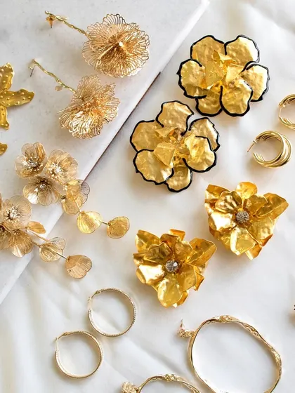 A little something for every mood. This flat lay shows off our collection of statement floral earrings, from textured drops to chunky metallic flowers and classic hoops. These are the pieces that effortlessly complete your look.