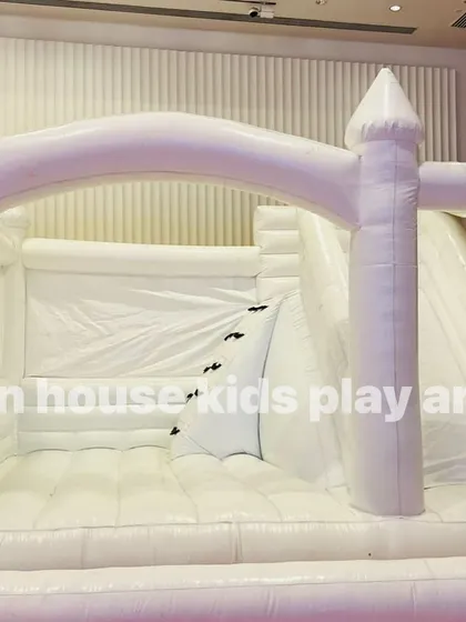 A close-up view inside our white bounce castle, focusing on the climbing ramp that leads up to the slide.