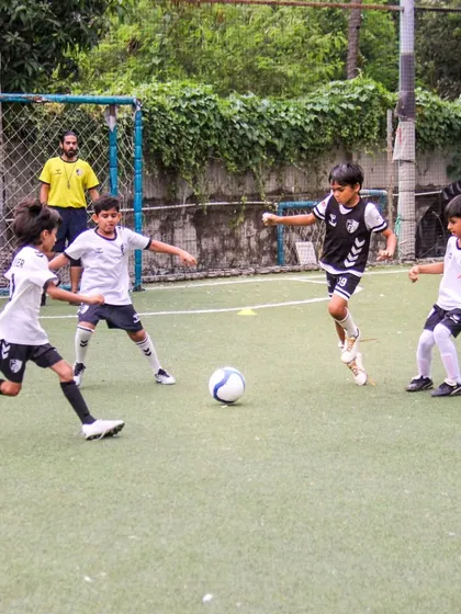 Players compete for possession in a crowded space, learning to make quick decisions and work together to create scoring opportunities.