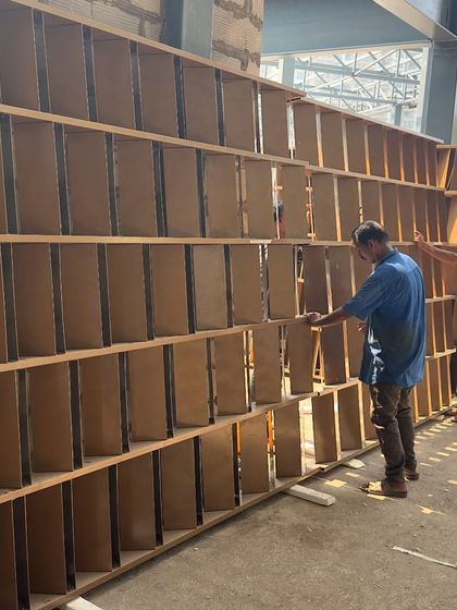 Workers installing the modules of the parametric jaali wall. This data-driven screen is crafted to optimize shade and visual permeability.