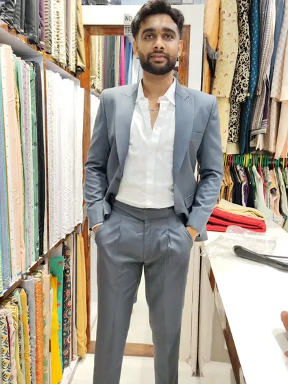 Modern tailoring for the modern man. Here, a client wears a custom-fit light grey peak lapel suit paired with contemporary Gurkha pants, a perfect example of how we can blend classic and unique styles.