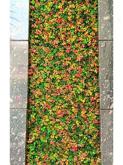 The texture and vibrant colors of the artificial plants create a rich, tapestry-like effect.