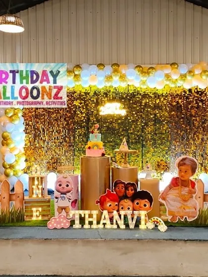 Bring the world of Cocomelon to your party with a bright and cheerful setup. This decoration uses a gold sequin and leaf wall, life-sized cutouts of JJ and his friends, a custom milestone board, and themed props to create an immersive experience for toddlers.
