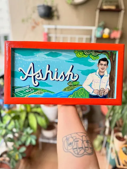 A custom name board we created for Supriya as a gift for her friend Ashish. We incorporated his interests, like tennis and coffee, into the background to make it truly personal.