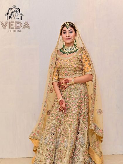 A bride looking absolutely radiant in a golden-beige lehenga with delicate floral embroidery.