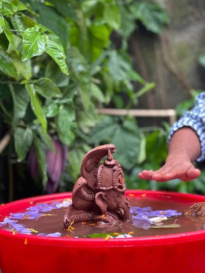 A moment of reverence during the visarjan. Our eco-friendly idols are designed to dissolve harmlessly in water, completing the natural cycle.