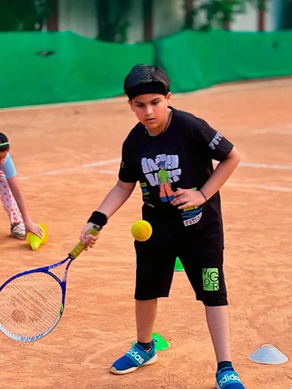 A player practicing a drill to improve hand-eye coordination by balancing the ball on his racket. This helps develop a better feel for the ball.