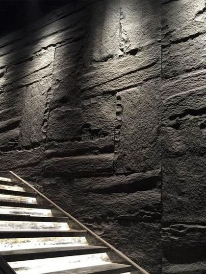 Our PU stone panels used along a staircase, adding texture and a dramatic flair to an often-overlooked area. The lighting from above highlights the rugged surface.