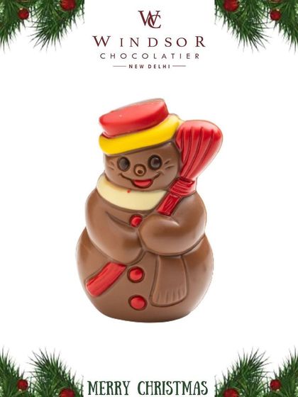 This happy chocolate snowman, complete with a scarf, hat, and broom, is a classic Christmas confection made from premium milk chocolate with colorful accents.