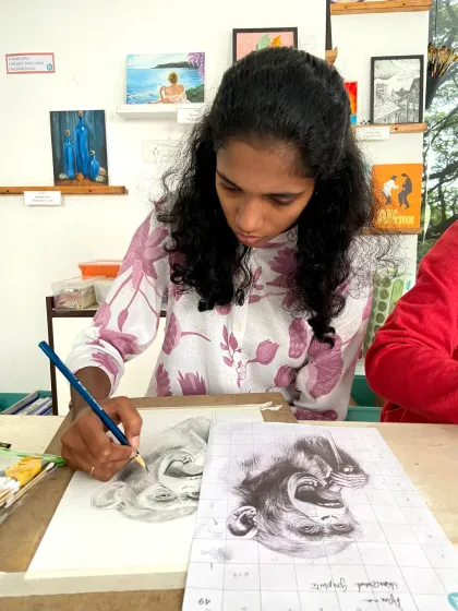 A teen student uses the grid method to create a detailed portrait sketch. This foundational technique is a key part of our curriculum, helping students achieve accurate proportions and realistic details in their drawings.