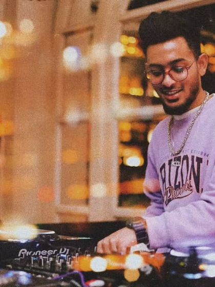 A warm, candid shot of me smiling while I mix. I genuinely enjoy what I do, and that passion translates into the energy of my performance.