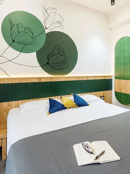 Personalization is key to making a house a home. In this master bedroom, I designed a custom hand-painted floral motif that flows from the wall onto the headboard, creating a unique piece of art that is integrated directly into the room's architecture.