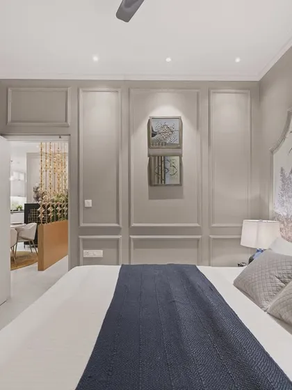 This angle reveals the bedroom's connection to an adjoining space, highlighting the open and flowing layout. The mirrored wardrobe reflects the room, creating an illusion of greater space and light.