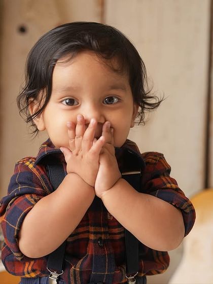 A shy, sweet moment with hands over his mouth. This captures the quieter side of a toddler's personality, even during a fun themed shoot.