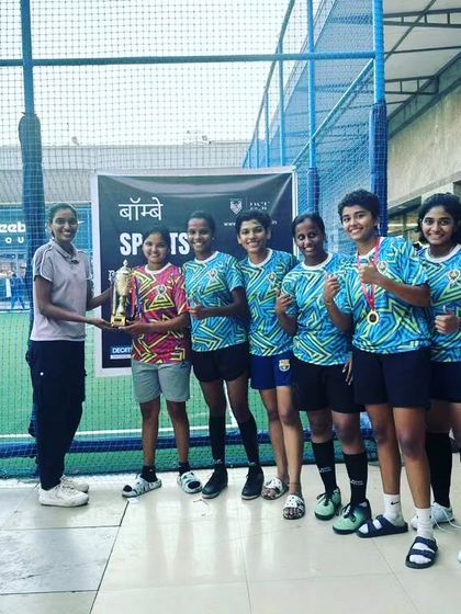 The Golden Eagles women's team celebrating their runners-up finish at the Bombay Football Festival. We are committed to promoting women's football and celebrating their achievements.