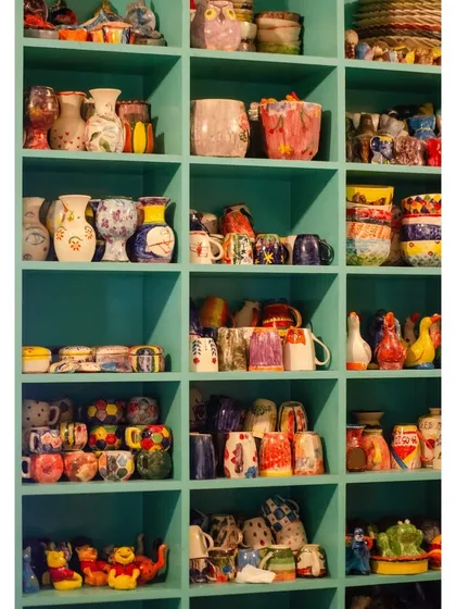 A look at the colourful results of our community's creativity. These shelves are filled with hand-painted ceramics, each one a unique piece of art made by guests just like you.