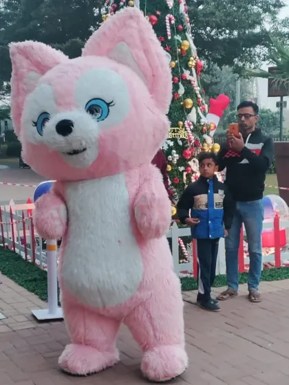 A guest takes a photo of his child with the pink squirrel mascot, capturing a happy memory from the event.