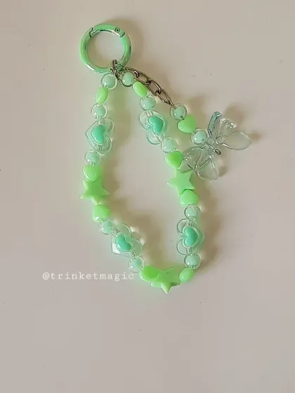 The pastel green beaded keychain, featuring minty green hearts and stars, and a translucent butterfly charm. It's fresh, cute, and so trendy.