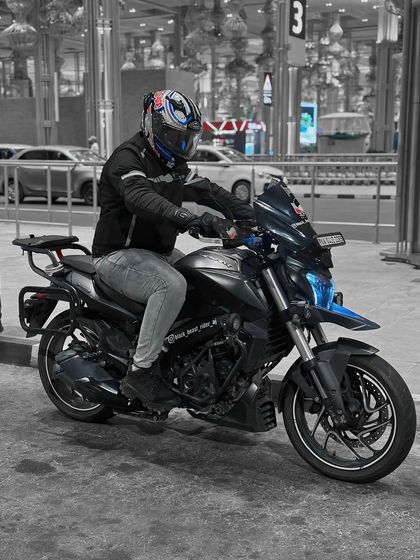 A rider on his beast, a modified Dominar 400, ready to roll out. The custom blue-tinted headlight adds a unique touch.