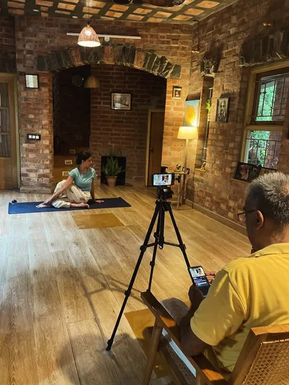 We use a simple setup to broadcast our live classes, focusing on clear instruction and demonstration. Here, a student practices a spinal twist, guided by our teacher through the screen.