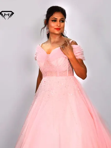 A soft and romantic baby pink ball gown. The off-shoulder design and sparkling beaded bodice create a classic princess look, perfect for any fairytale occasion.