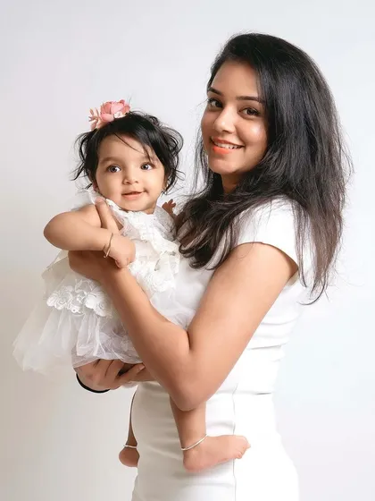A simple and elegant mother-daughter portrait. The clean white background keeps the focus on their sweet connection.