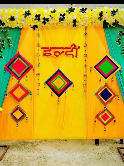 A similar Haldi backdrop design using a teal and yellow color scheme. I can customize the fabric colors and decorative elements to match your event's theme or your personal preference.