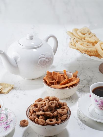 A lovely tea time spread featuring some of my favourites. In the bowls are my ring-shaped Kodbale and flat Ribbon Murukku, alongside a platter of classic murukku, all ready to be enjoyed.