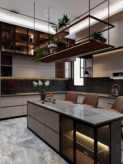 This kitchen in Alameda, Gurgaon, is the heart of the home, combining function with high-end aesthetics. It features a large marble-topped island with seating, extensive custom cabinetry for smart storage, and a suspended shelving unit with integrated planters, blending utility with a touch of nature.