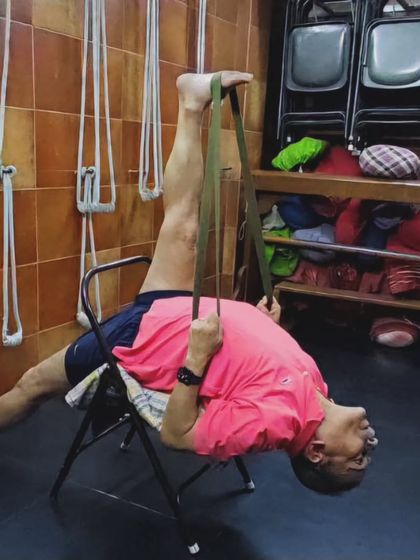 A supported leg stretch using a chair and strap. This allows for a deep, controlled release of the hamstring muscles.