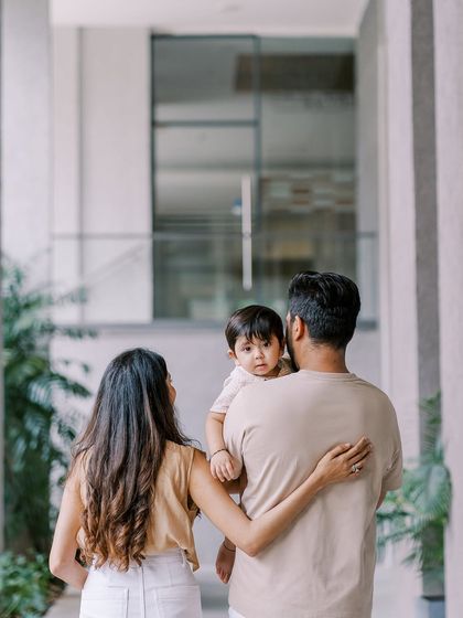 A family walking away, with the baby looking back over his father's shoulder. A beautiful, storytelling shot from a first birthday session.